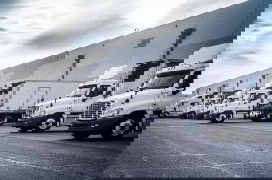 White trucks parked in a loading dock.