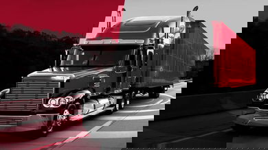 black and red truck cruising down highway