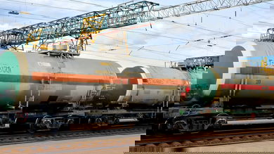 Two tank cars sit in a railroad yard.