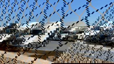 Used trucks behind fence