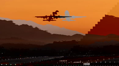 airliner taking off at sunset