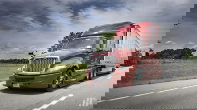 Red truck driving on highway in rural area