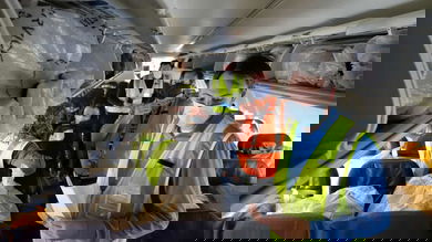 People putting boxes in passenger seats