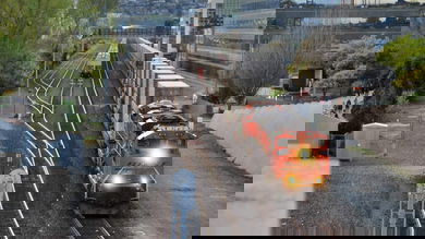 A photograph of a train heading through a downtown area.