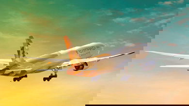 A jet takes off into a sunset sky.