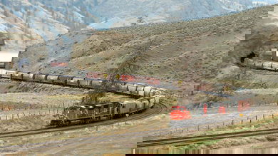 A photograph of a train hauling dozens of railcars behind it.