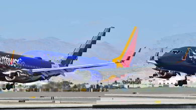 A bright blue and orange Southwest plane landing.