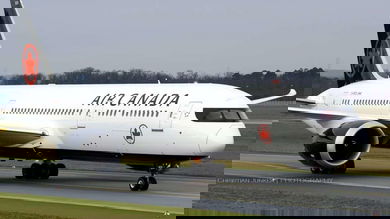 Big white Air Canada jet on runway.