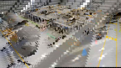 Partially assembled sections of a plane in a factory.