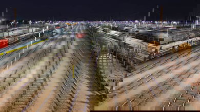 A photograph of a rail yard at night.