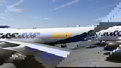 White jumbo jet sits on ramp at airport.