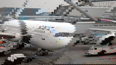 A white El Al plane at the airport gate.