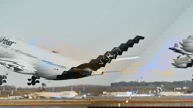 A big white Lufthansa plane takes off.