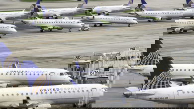 White regional jets parked at airport.