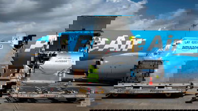 Light blue Amazon Prime plane with cargo door open, waiting for a load.