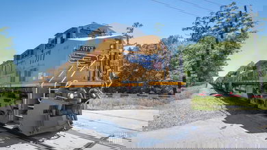 A photograph of a train locomotive on a train track. There is a forest next to the train track.