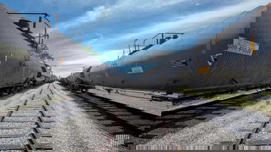 A photograph of tank cars in a rail yard. The tank cars are in lined up left and right.