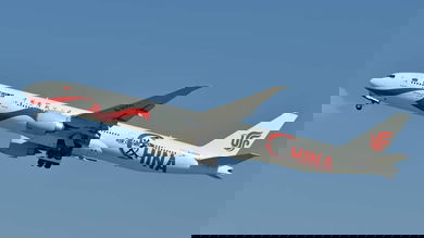Big white jet in air after takeoff, flying overhead