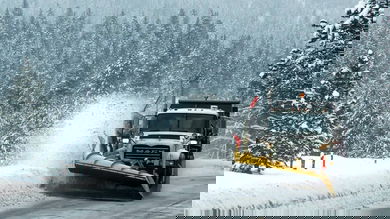 Plow clearing snowy Idaho highway.