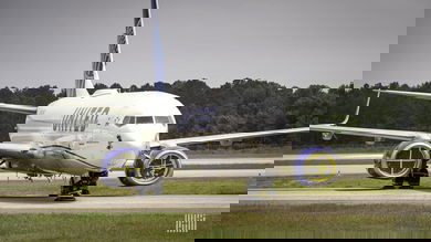 A white United Airlines plane in storage on tarmac.