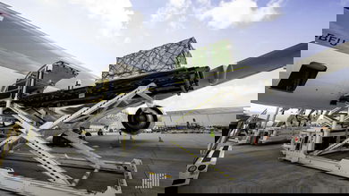 Machine lifts cargo pallets up to door of plane for loading.