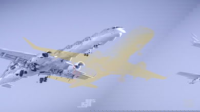 Looking up at a silver plane overhead coming in for landing at airport.