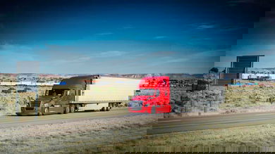 Truck on highway with intermodal train in the background
