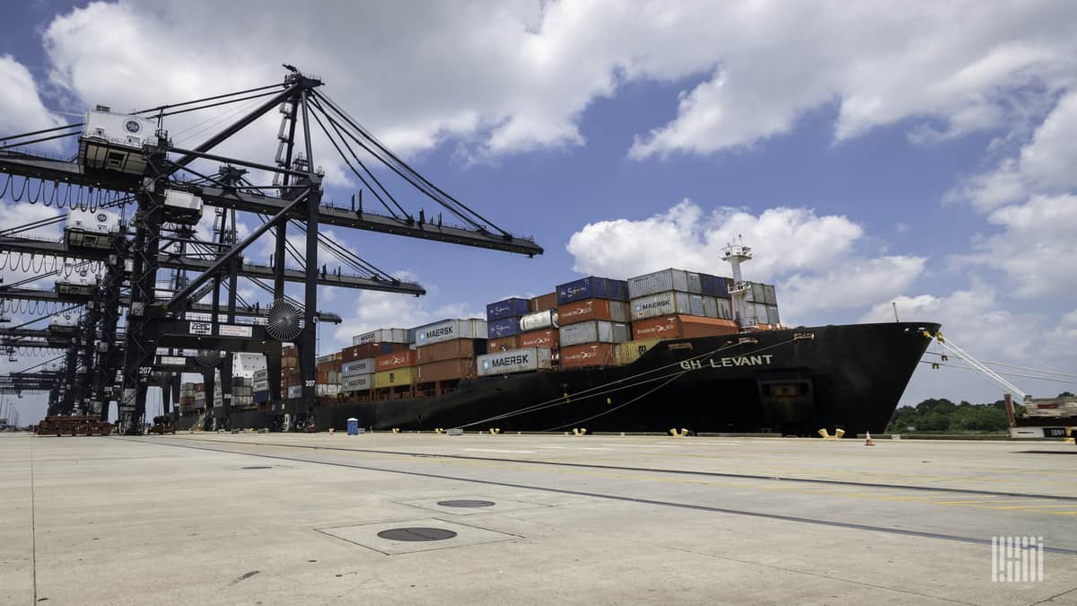 A cargo ship ready to be unloaded lies at a dockside.