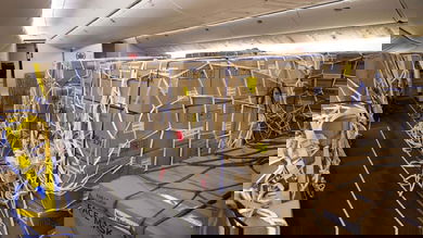 Boxes of face masks and tied down with nets on the passenger cabin floor of plane after seats were removed. Air Canada was faster than U.S. airlines to modify planes for this type of cargo operation.