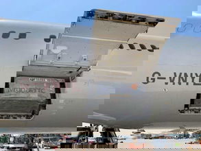 Cargo door open with a container resting in the hold of a Virgin Atlantic plane.