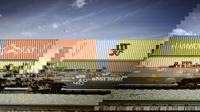 A photograph of a double-stacked intermodal train parked at a rail yard.