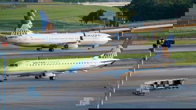 White jets with blue tails pass each other at Houston's main airport.