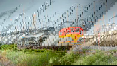 A photograph of a Kansas City Southern train traveling by an industrial yard.