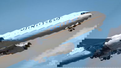 A white United Airlines plane takes off , view from behind.