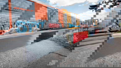 A photograph of a train passing by a rail crossing.