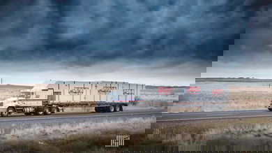 A tractor-trailer of CCC Transportation drives on a road. TFI International has acquired CCC from Comcar Industries.