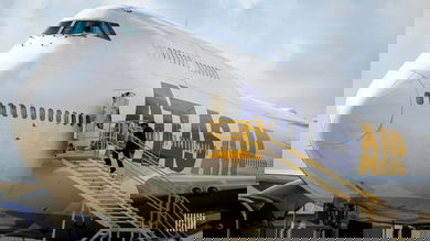 A white Atlas Air jumbo jet, with man walking up stairs into side door.