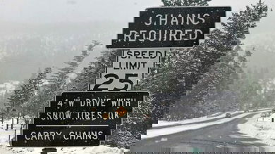 "Chains required" sign along a snowy California highway.