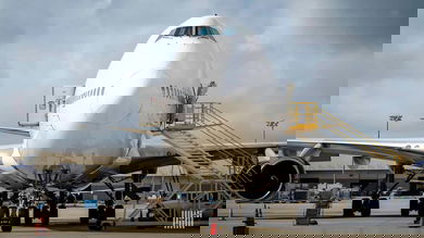 Front-end of a Boeing 747 cargo jet, looking straight on to its nose. The plane is white.