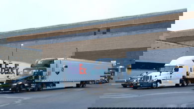 A FedEx and UPS tractor trailer at a loading dock.