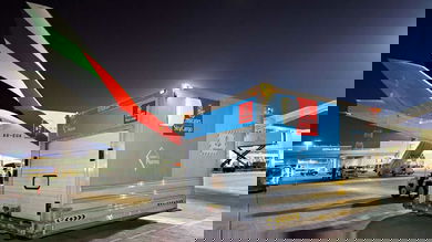 A cargo container on the tarmac at night after being unloaded from a large jet.
