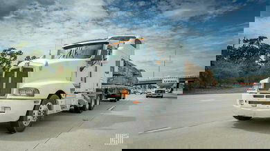 A front view of a truck hauling a trailer with lumber. Canadian trucking company BLB shut down recently.