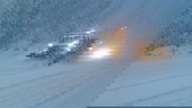 Plow truck trying to clear a snowy California highway. during a blizzard