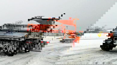 Plow trucks on a snowy Illinois highway.