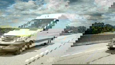 A photograph of a van driving on a road.