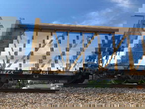 A photograph of a centerbeam car on a railroad track.