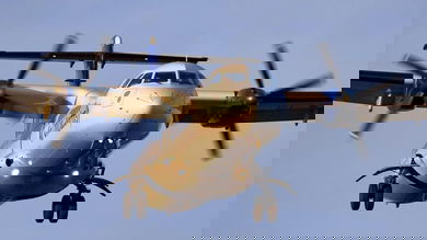 A turboprop ATR plane comes in for landing, view from straight on below the plane.