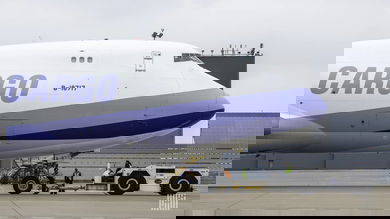 A 747 jumbo jet with white paint and light blue accents with the word CARGO on the side.