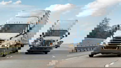 Two white trucks sharing the highway