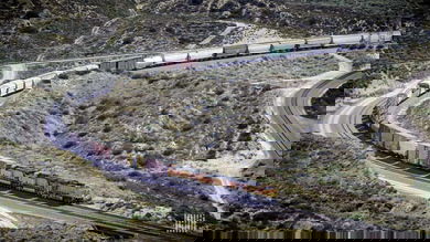A photograph of a Union Pacific train weaving through a valley.